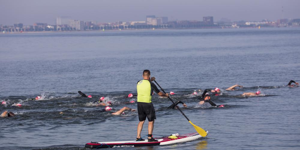 Zwemmer en sup tijdens zwemevenement Rondje Pampus