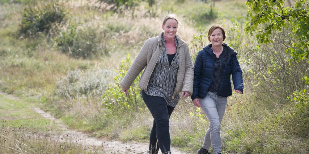 twee vrouwen wandelen in de duinen